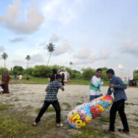 young teen boys punching a bop bag