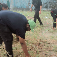 man bend down to pick waste