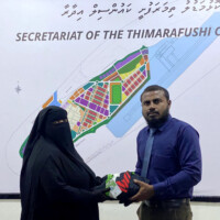 man giving clothes to a woman in niqab