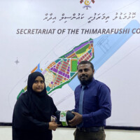 Man handing over a uniform to a little girl