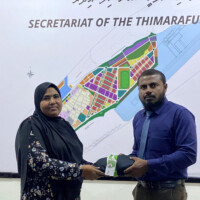 secretary general giving Thimarafushi office uniform to a staff
