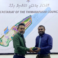 Council president Ismail Ibrahim handing over a uniform to SG Ahmed Ilham