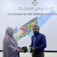 woman in burqa and a man holding a piece of clothe