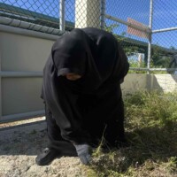 woman in burka cleaning ground