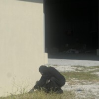 aunty squatting to pull weed from field