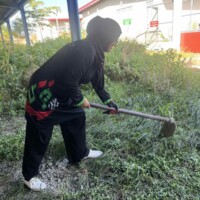 woman with a grub hoe digging