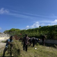 man carrying, cleaning, a grass field