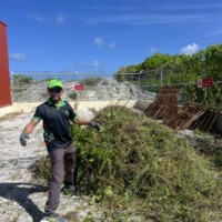 man showing a large pile of vine, grass, waste