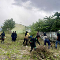 Maldivians cleaning a grass field