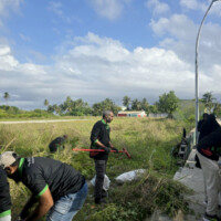 group of people cleaning a field
