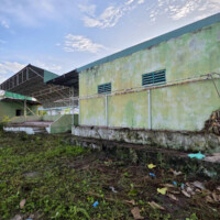a field with an old building and a rostrum