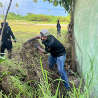 Man pulling a large grass sheet
