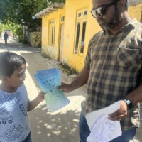 Thimarafushi MCEP survey team member giving leaflets