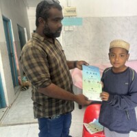 Thimarafushi MCEP survey team member giving leaflet to a kid